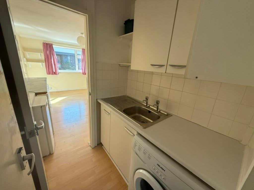 Lot: 121 - GROUND FLOOR APARTMENT FOR IMPROVEMENT - Kitchenette view showing sink and doors leading to living room